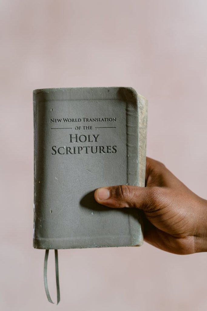 Close-up of a hand holding the Holy Scriptures, focusing on religious and spiritual themes.